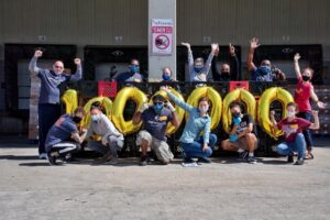 People posing around balloons that spell out "1,000,000"