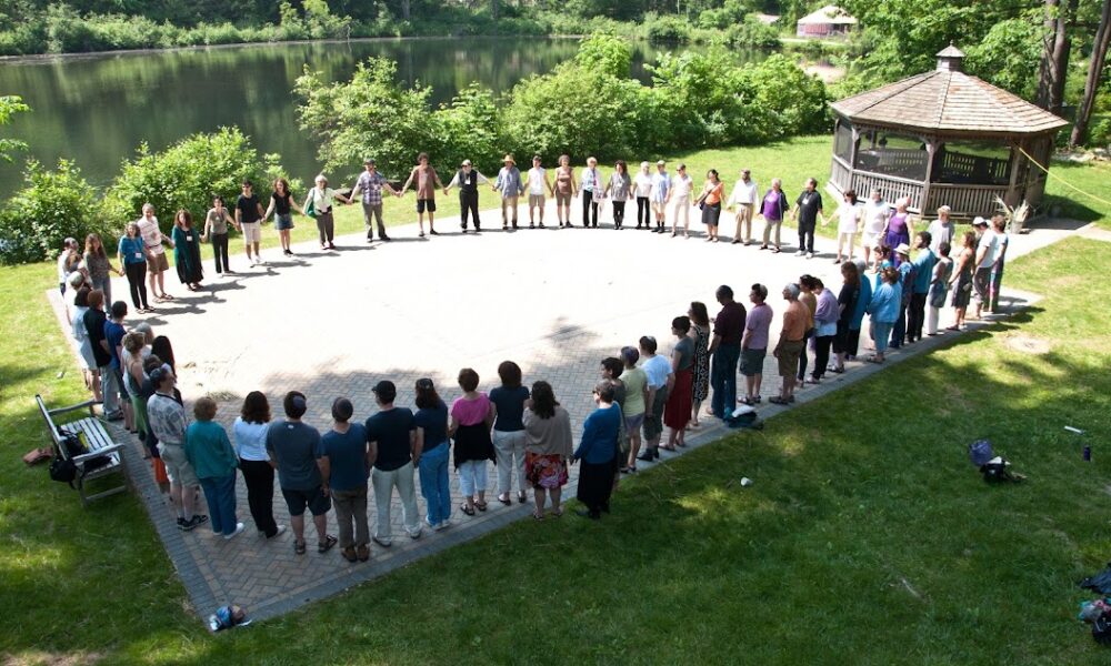 Group of people in large circle outside