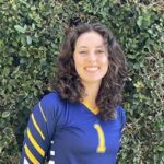 Roz Larsen, a Jewish woman with curly brown hair and a blue and yellow shirt.