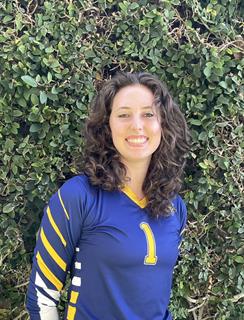 Roz Larsen, a Jewish woman with curly brown hair and a blue and yellow shirt.